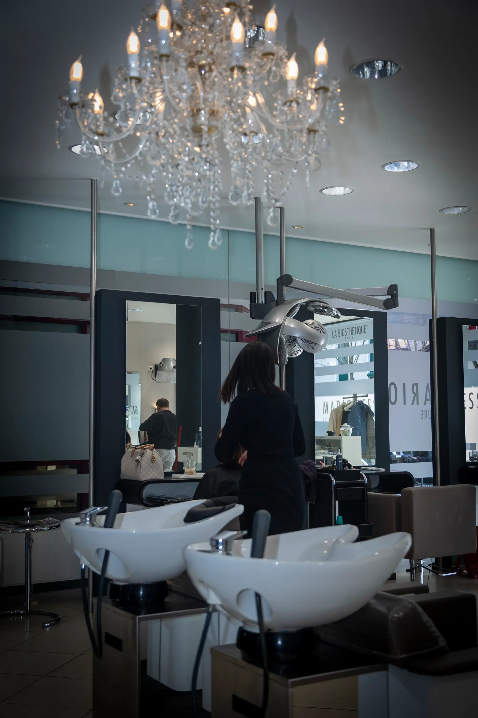 Kronleuchter und Waschtische im stilvollen Interieur von Mario Dessi Friseure